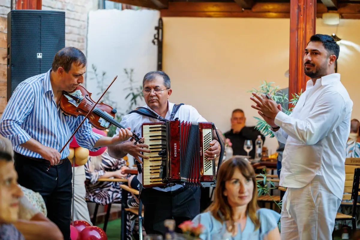 Violin and accordion played between the tables, a guest clapping along beside them