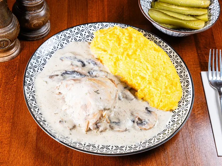 A plate of chicken ciulama (creamy mushroom stew) with mushrooms, at Ciorbe La Ion
