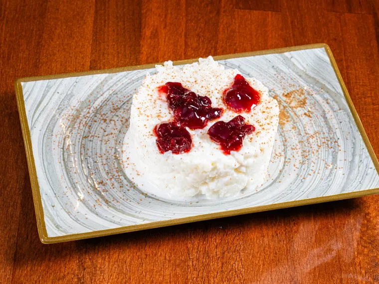A plate of milk rice pudding with cinnamon & sour cherry preserve, at Ciorbe La Ion